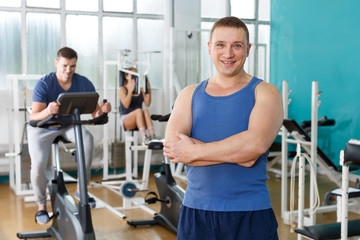 Fototapeta na wymiar Guy posing among sports equipment at gym