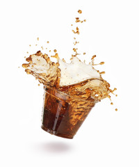 splash of cola in a plastic glass on a white background
