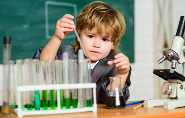 little boy at lesson. Back to school. Little kid learning chemistry in school lab. Biology lab equipment. Little boy at the elementary school. school kid scientist studying science. Confident doctor