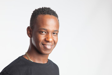Retrato de un joven de origen africano de piel oscura, mirando a cámarta