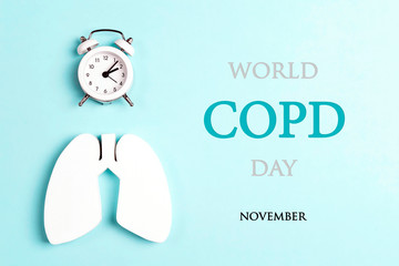 World COPD day concept with lung symbol and alarm clock on a blue background.