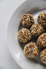 Energy balls – homemade healthy dessert cooked with dates, nuts, dry fruits and cocoa. Organic dry fruits snacks on marble background