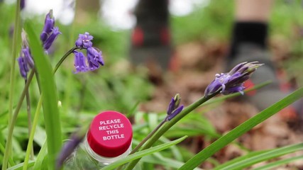 Saving The Environment Boy Litter Picking Plastic Bottle From Wild Bluebell Flowers