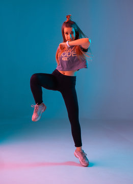 Young stylish girl dancing zumba in the Studio on a colored neon background. Dance poster design.