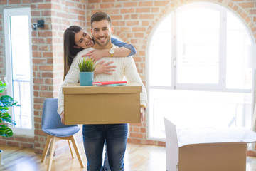Fototapeta na wymiar Beautiful young couple moving to a new house, smiling happy holding cardboard boxes at new apartment