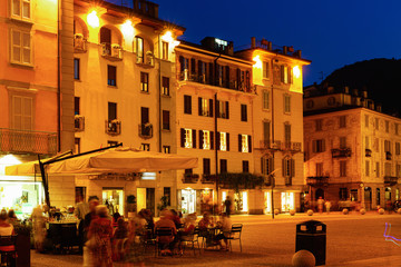 Streets and buildings of Como city in evening near mountains in Italy