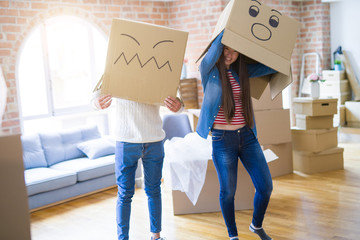 Fototapeta na wymiar Crazy couple wearing boxes with funny faces over head, having fun happy for moving to a new house