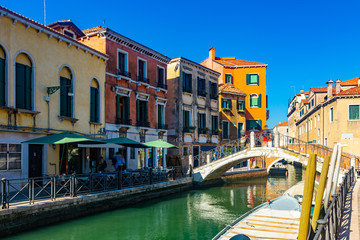Fototapeta na wymiar View of canals and cityscape with colorful buildings in Venice