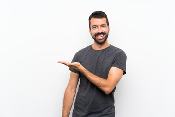 Young handsome man over isolated white background presenting an idea while looking smiling towards