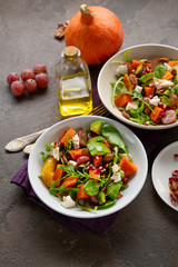 Tasty salad with orange and pumpkin in bowls