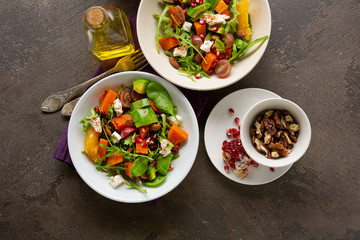 Tasty salad with orange and baked pumpkin in bowls