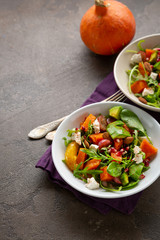 Tasty salad with avocado and baked pumpkin in bowls