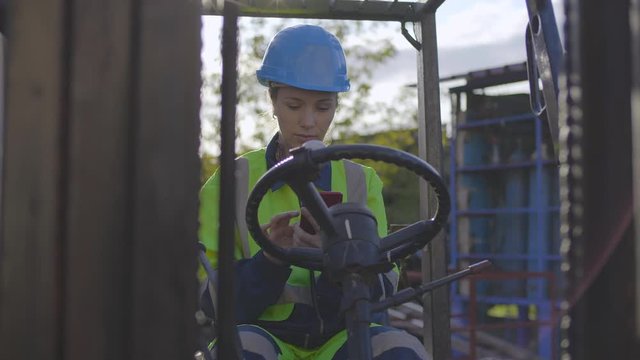 Woman forklift truck driver in an industrial area