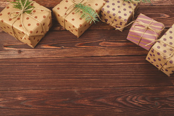 Stylish decorated christmas gifts over brown wooden background