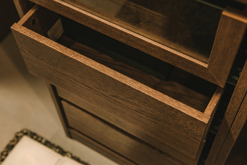 Wooden cupboard with opened empty drawer.