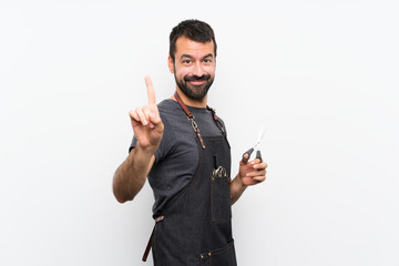 Barber man in an apron showing and lifting a finger
