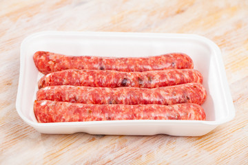 Uncooked sausages on wooden table