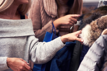 Adult women shopping for clothes in boutique in autumn