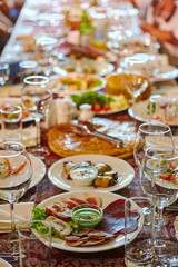 A group of people at a long table with food. The concept for the joint celebration of memorable dates or holidays