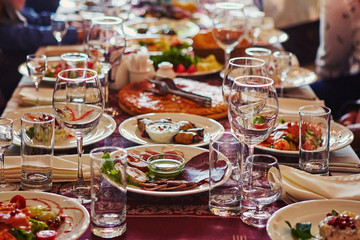 Obraz na płótnie Canvas A group of people at a long table with food. The concept for the joint celebration of memorable dates or holidays