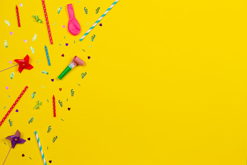 Bithday party decorations on yellow background, top view