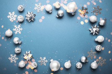 Merry Christmas and Happy Holidays greeting card, frame, banner. New Year. Noel. Christmas white, silver .ornaments on blue background top view. Winter xmas holiday theme. Flat lay