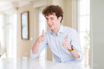 Young business man with curly read head pointing fingers to camera with happy and funny face. Good...
