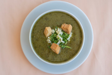 Green cream soup from spinach with croutons, cheese and fresh parsley