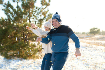 The guy with the girl throw confetti in the winter forest