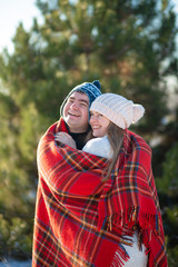 Winter walk through the woods. The guy in the red plaid blanket wraps the girl up so she gets warm