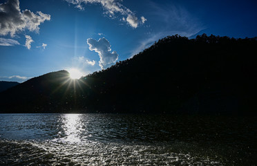 Sun behide mountain with blue sky