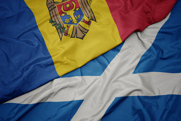 waving colorful flag of scotland and national flag of moldova.