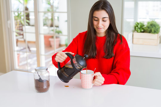 Young beautiful woman making morning coffee smiling, preparing a cup of latte for breakfast