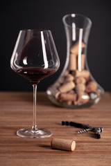 Crystal red wine glass, bottle, corkscrew, opener, sommelier knife, transparent decanter, corks on...