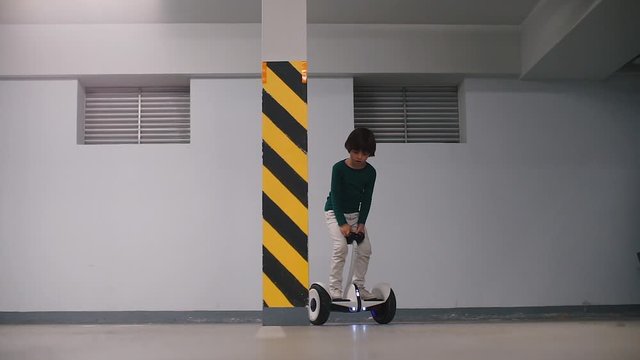 A boy parks a gyroscooter in an underground parking garage