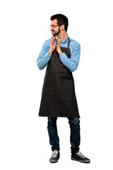 Full-length shot of Man with apron scheming something over isolated white background