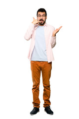 Full-length shot of Handsome man with beard making phone gesture and doubting over isolated white background
