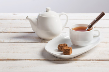 Fototapeta premium cup of tea with chocolate candy on wooden table