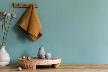 Stylish scandinavian dining room interior with wooden tray, cement fruits, flowers in vase and elegant accessories. Copy space. Ready to use. Template. Eucalyptus color concept. Modern home decor.