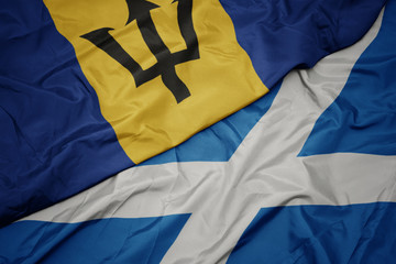 waving colorful flag of scotland and national flag of barbados.