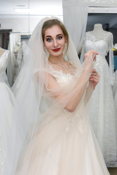 Bride in wedding dress fitting it in atelier