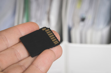 documents and hand holding flash drive, selective focusing, document transfer concept, and paper saving thanks to electronic media, tinting