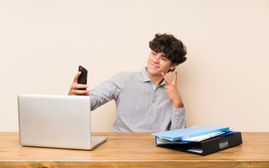 Young student man with a laptop making a selfie