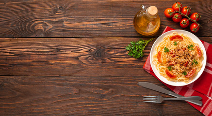 Pasta bolognese with tomato sauce and minced meat, grated parmesan cheese and fresh parsley - homemade healthy italian pasta on rustic wooden background. Flat lay. Top view.