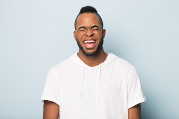 Portrait of overjoyed african American man in glasses laughing