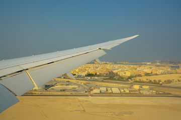 Airplane wig landed in the desert city in Bahrain over blue sky background.