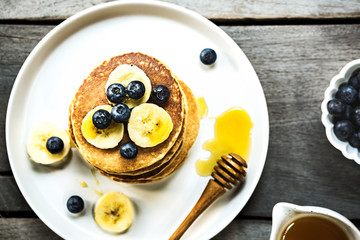 Banana Oat pancakes with honey and blueberries