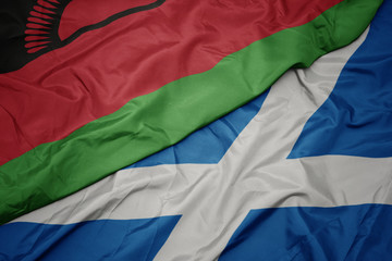 waving colorful flag of scotland and national flag of malawi.