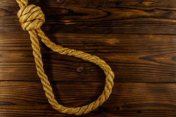 Deadly loop of rope on a wooden background. Concept of death penalty or suicide