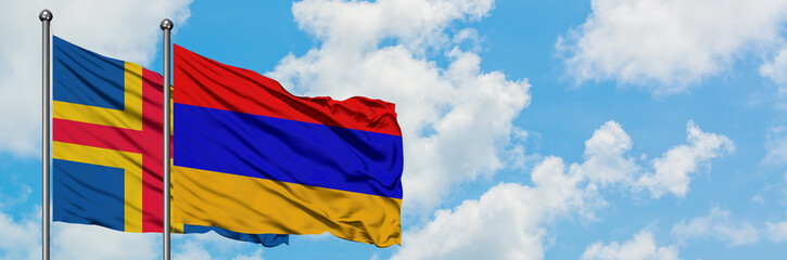 Fototapeta na wymiar Aland Islands and Armenia flag waving in the wind against white cloudy blue sky together. Diplomacy concept, international relations.